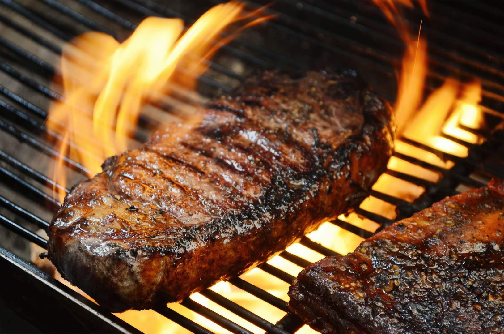 Steak über offener Flamme auf dem Grillrost